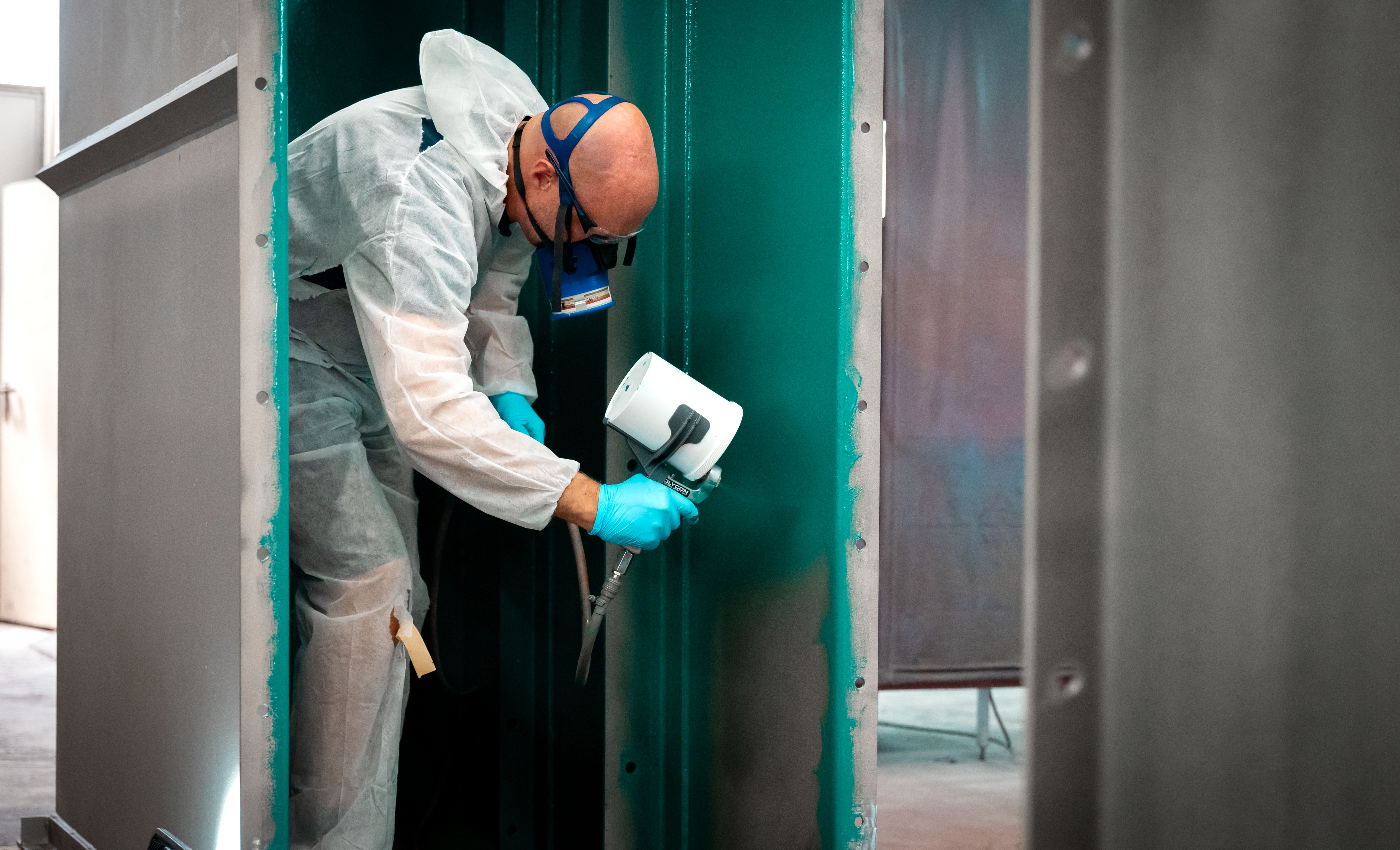 Un uomo con una maschera spruzza uno strato di controllo verde