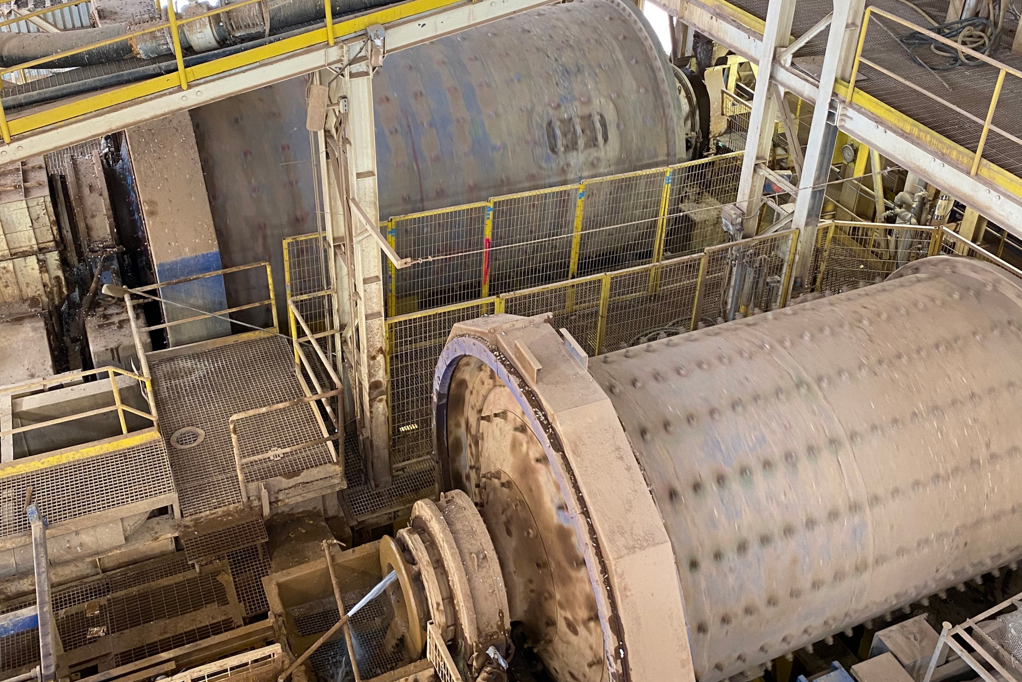 Grandi mulini industriali a tamburo installati all'interno di uno stabilimento di lavorazione dei materiali[cite: 6].